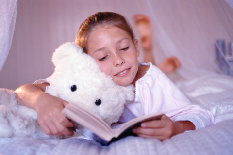 child reading with teddy bear