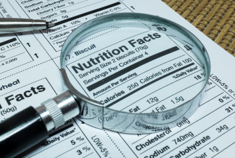 Magnifying glass on top of a sheet of nutrition facts.