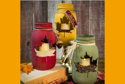 Three mason jars with a candle and beans inside.