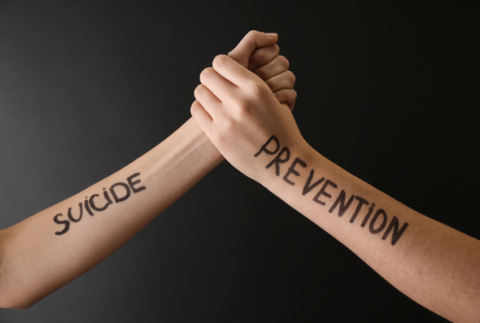 Two arms with suicide prevention written on them.