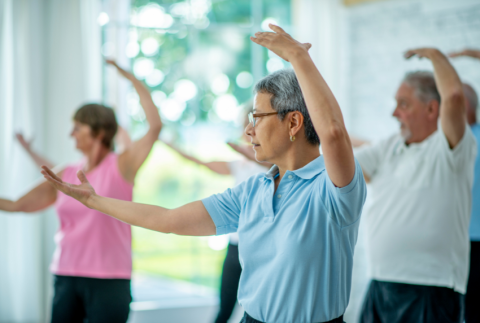 Side view of people doing Tai Chi.