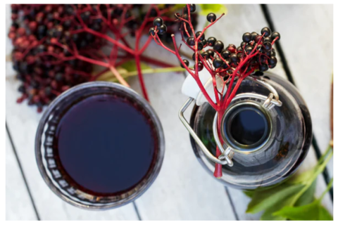 Glass of syrup and elderberries