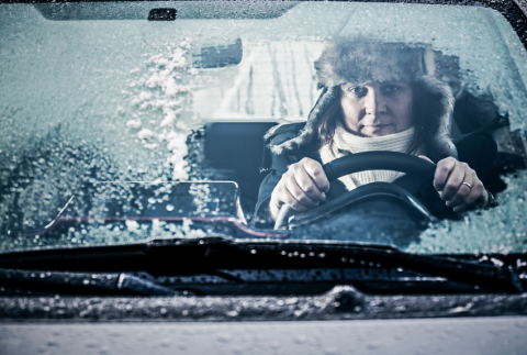 Lady driving with ice on wind shield.