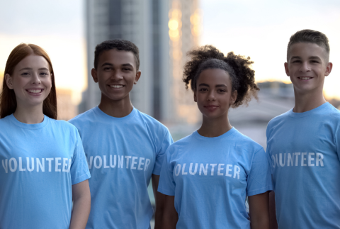 Group of teens with volunteer written on their shirts. 