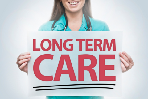 Nurse holding sign that reads long term care.