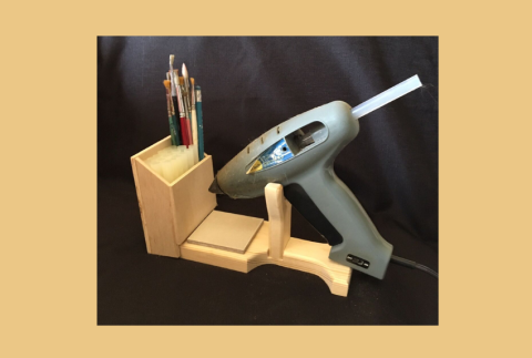 Side view of a glue gun and holder. 