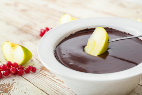 Apple being dipped in chocolate