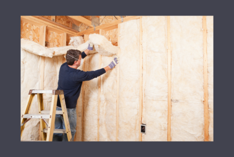 Man on ladder putting up insulation in walls. 