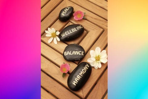 Colored background with rocks that read peace, harmony and balance. 
