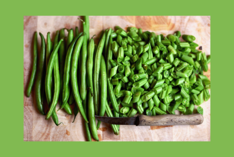Top view of green beans on a cutting board. 