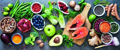 Picture of various foods that are healthy such as fish, berries, vegetables and nuts.