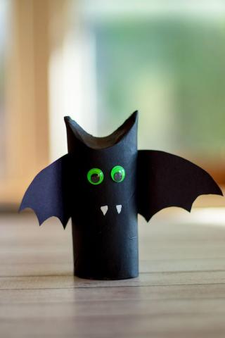 A  black bat made out of a toilet paper tube