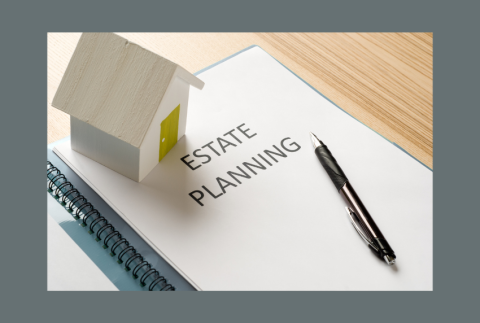 Top view of toy house on papers that read estate planning.