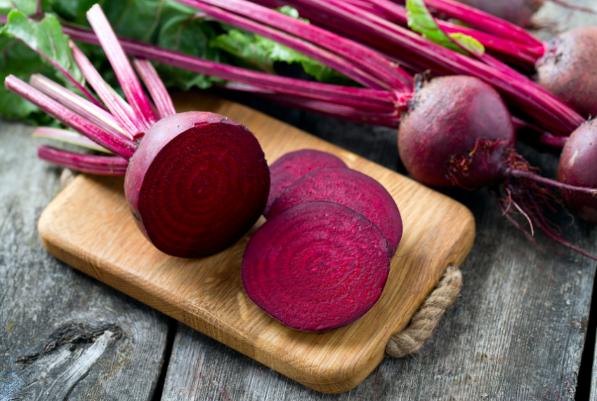 Cutting board with sliced beets on top. 