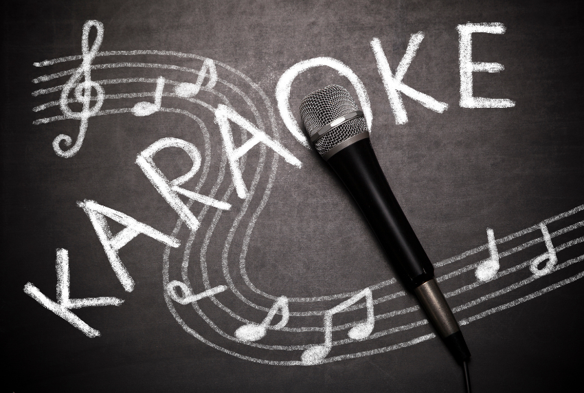 Chalkboard with word karaoke written in it with music notes and a microphone. 