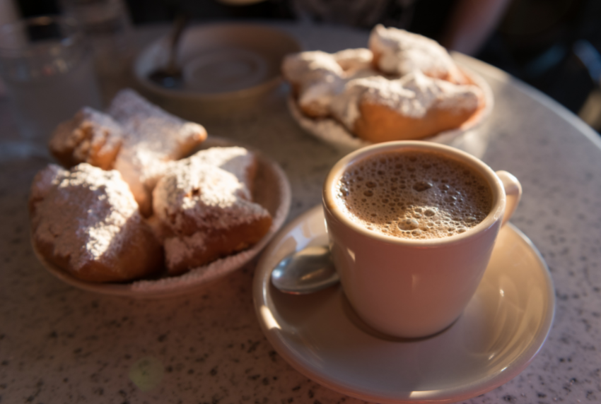 Top view of a cup of coffee and beignets. 