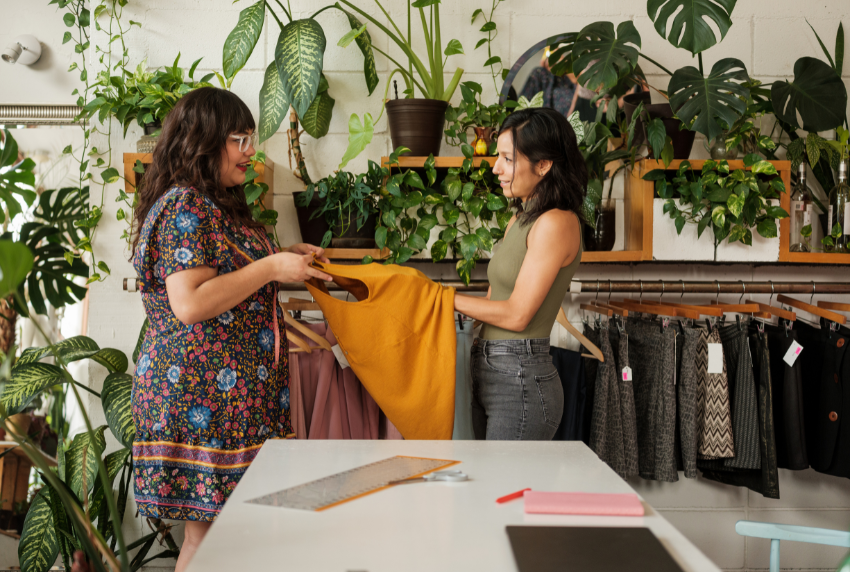 Plants and 2 people holding clothes.