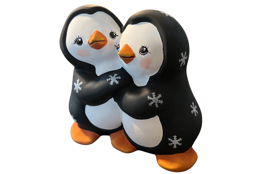 Two ceramic penguins holding hands.