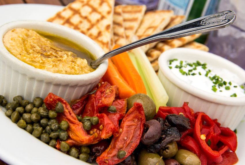 Side view of dips and olives.