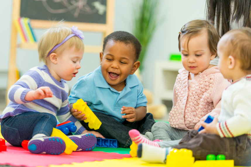 4 babies playing with toys