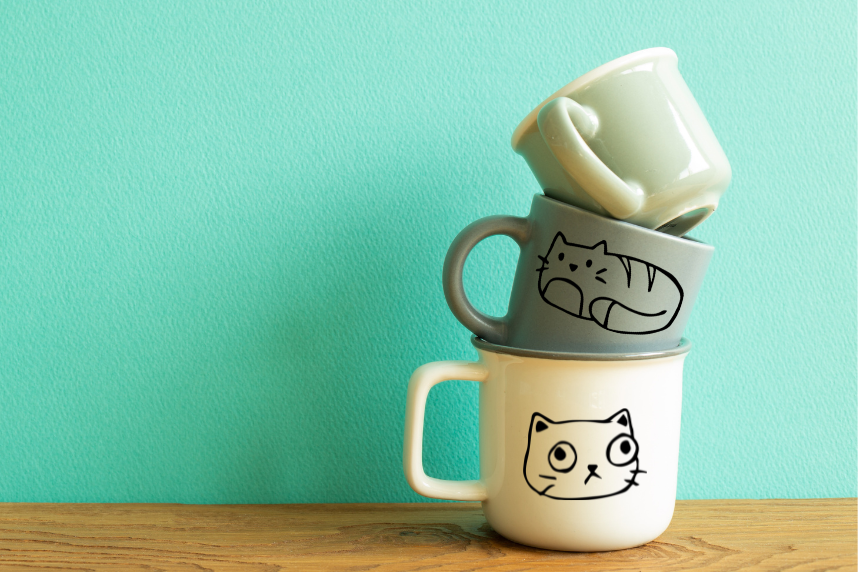 stacked mugs with cat drawings on them