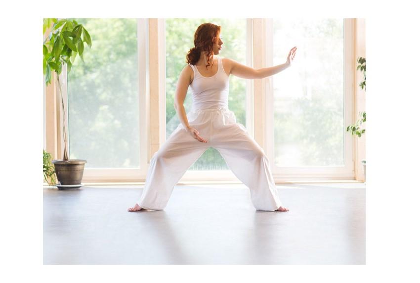 Woman practicing QiGong in a sunlit room