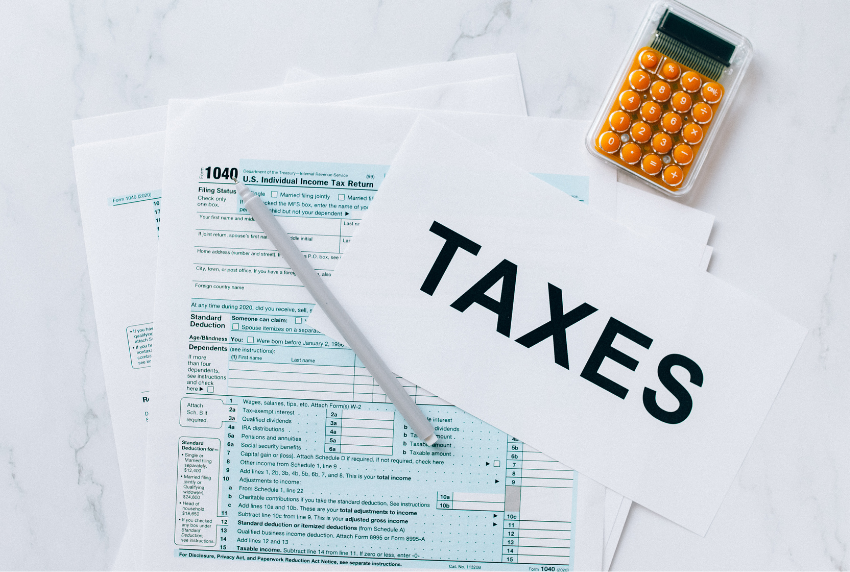 Top view of tax form, calculator and pencil. 