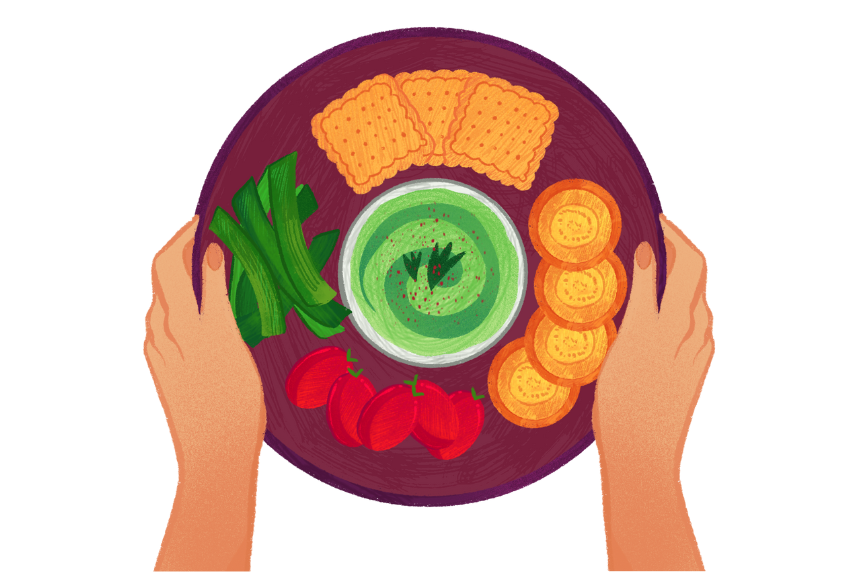 Hands holding a plate with dip and vegetables and crackers