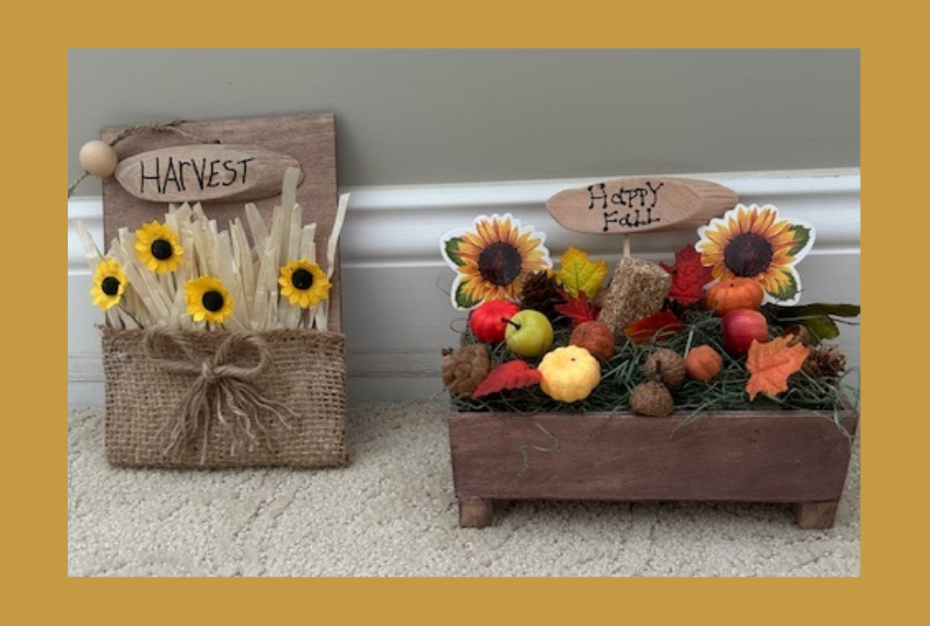 Two wooden fall harvest boxed with flowers. 